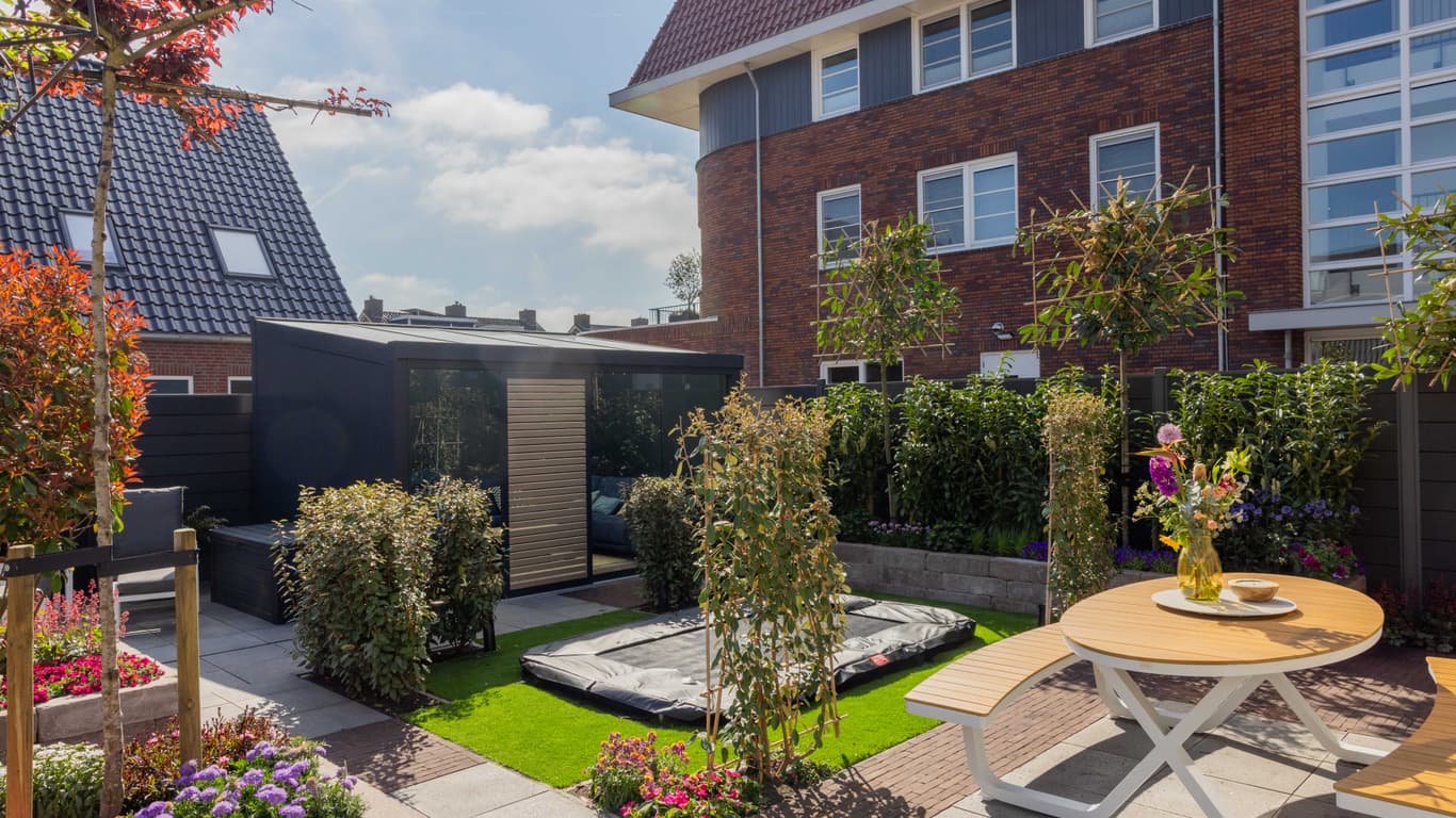 Vernieuwde tuin van Margriet en Roland met vrijstaande tuinkamer en beplanting in Bergambacht