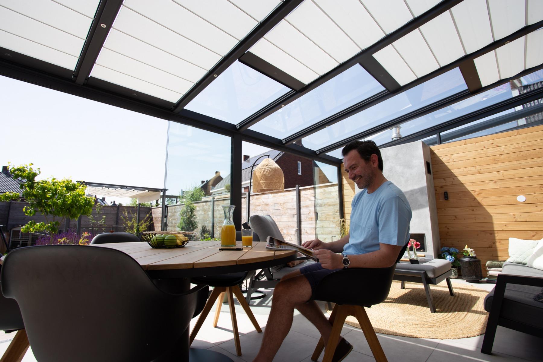 Automatische zonwering onder een anthraciet overkapping