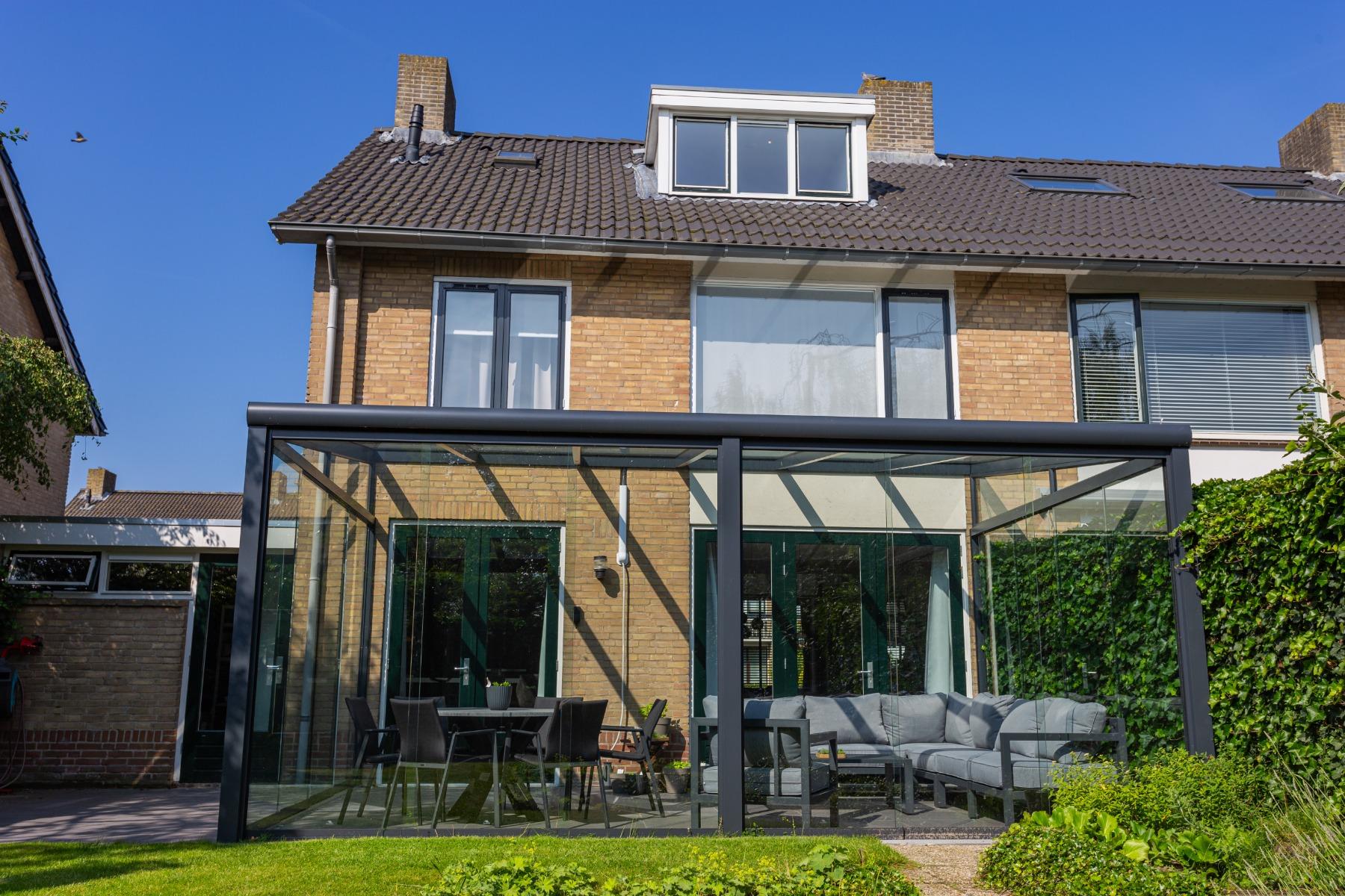 Moderne mat antraciete terrasoverkapping aan huis