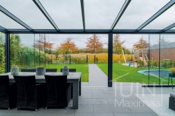 Moderne Gumax® Overkapping aan huis in mat antraciet van 8,06 x 4 meter met glazen dakplaten inclusief Gumax LED verlichting, glazen schuifwanden en Glazen spie
