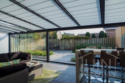 Moderne Gumax® Terrasoverkapping in mat antraciet van 8,06 x 4 meter met ingekorte glazen dakplaten inclusief Gumax zonwering, LED verlichting, glazen schuifwanden en vaste polycarbonaat zijwand