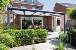Moderne terrasoverkapping aan huis met zonwering en glazen spie